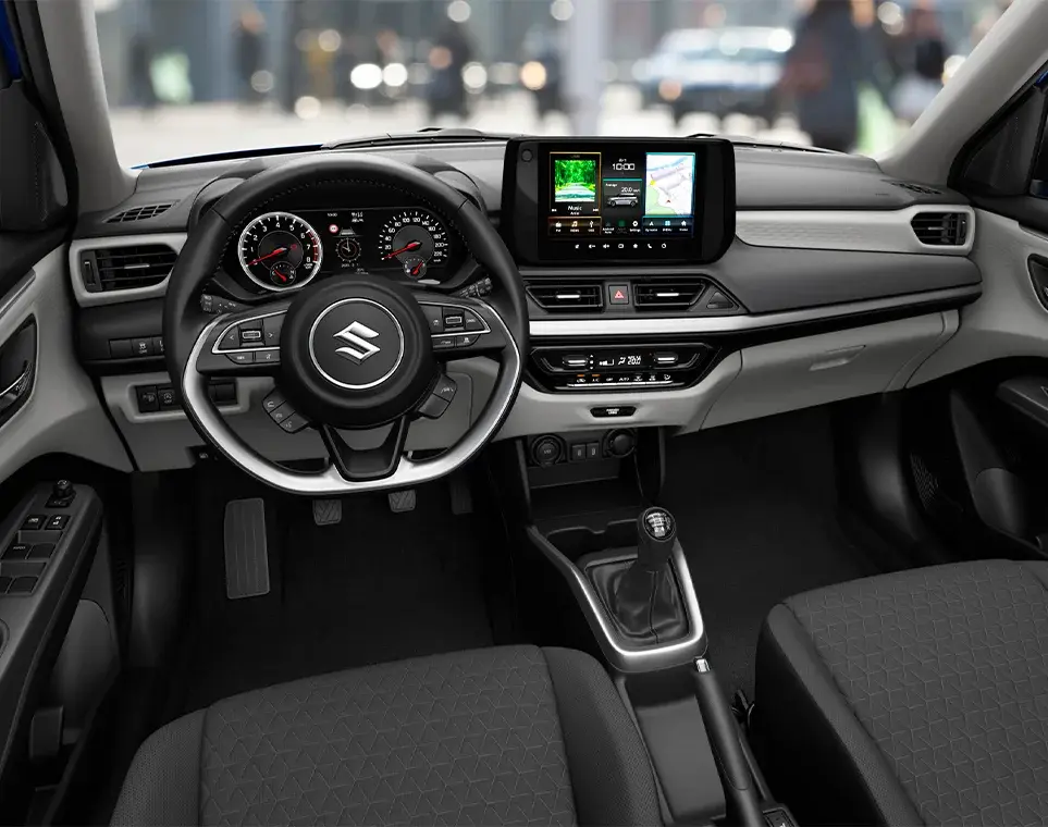 Interior moderno del Suzuki Swift Híbrido, destacando el volante multifunción y la pantalla táctil central.